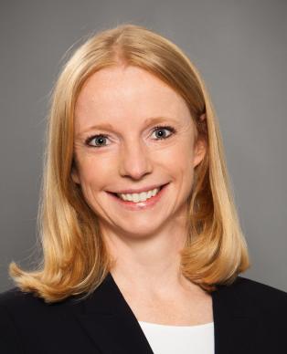 A woman in a blazer smiling